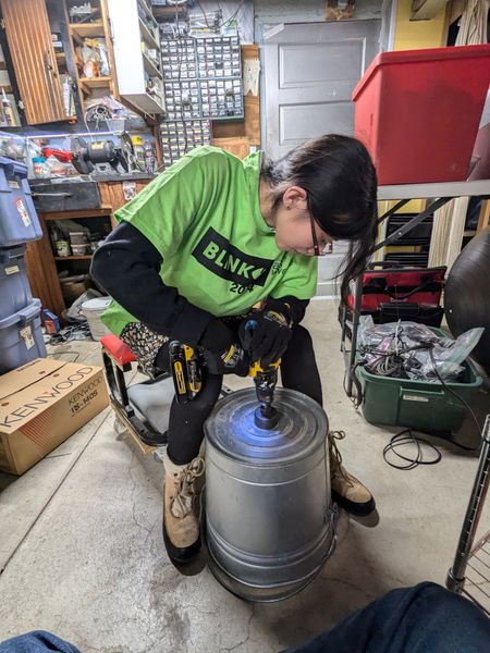 Grace drilling a hole in the top bucket